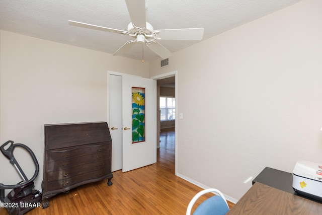 office area featuring ceiling fan, light hardwood / wood-style floors, and a textured ceiling