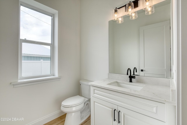 bathroom with hardwood / wood-style floors, vanity, and toilet