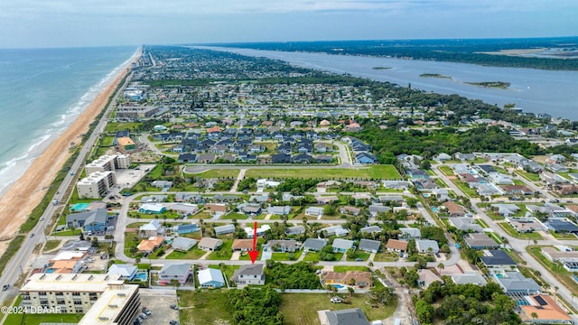 birds eye view of property with a water view and a beach view