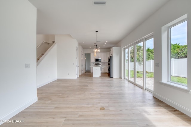 unfurnished living room with plenty of natural light and light wood-type flooring