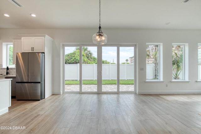 interior space with light wood-type flooring, plenty of natural light, and sink