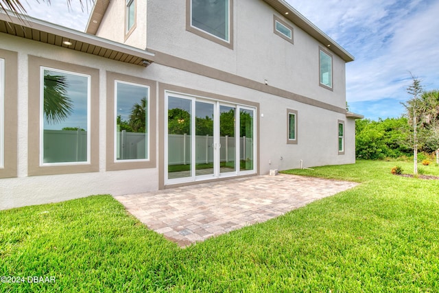 rear view of house featuring a lawn and a patio area