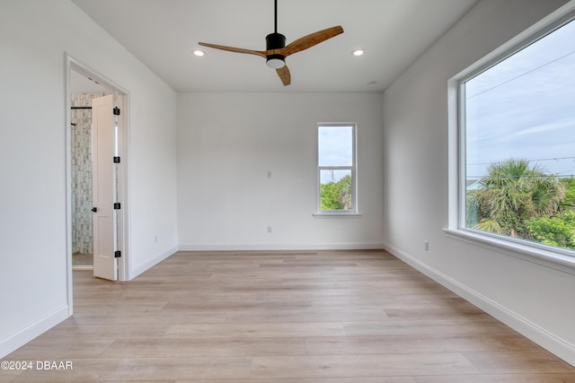 empty room featuring ceiling fan, a healthy amount of sunlight, and light wood-type flooring