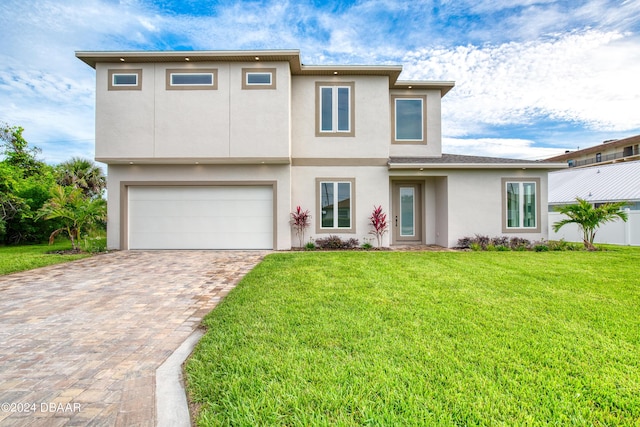 view of front of property with a garage and a front lawn