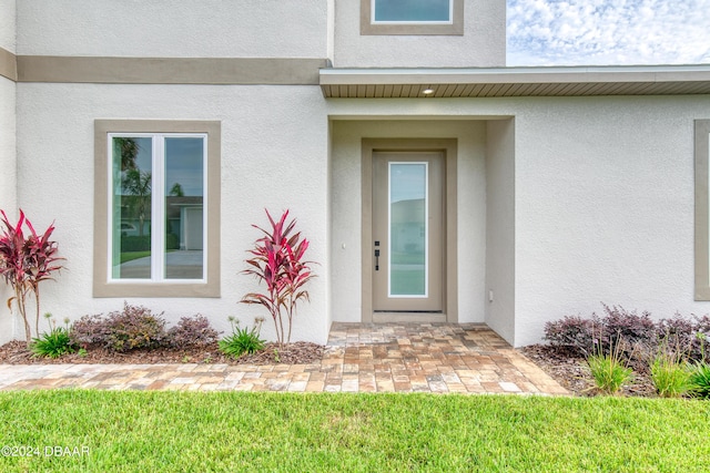 property entrance featuring a lawn