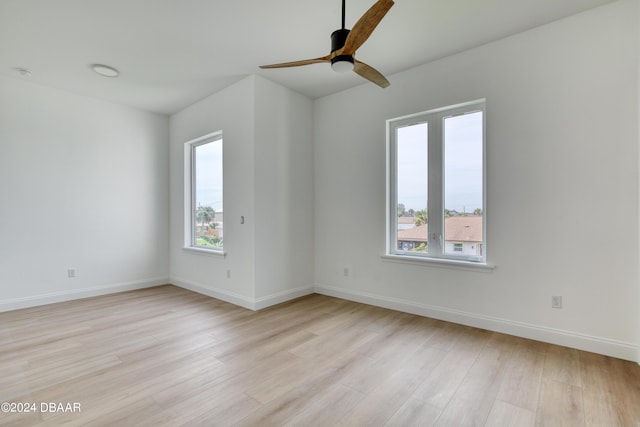 empty room with light hardwood / wood-style floors, ceiling fan, and a healthy amount of sunlight