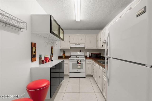 2711 N Halifax Ave Unit 372, Daytona Beach, FL 32118 - kitchen featuring white appliances, under cabinet range hood, a textured ceiling, light tile patterned flooring, and white cabinetry