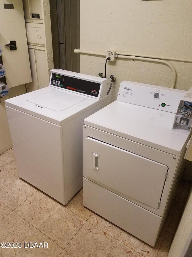 washroom featuring washing machine and dryer and light tile patterned flooring