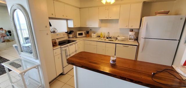 kitchen featuring butcher block counters, white appliances, and white cabinetry