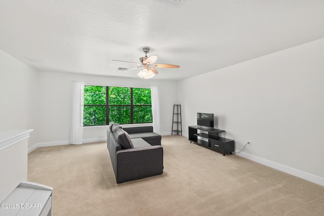 carpeted living area featuring a textured ceiling, visible vents, baseboards, and ceiling fan