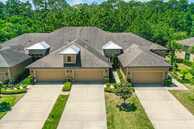 view of front of house with driveway, an attached garage, roof with shingles, and a front yard