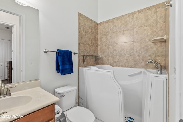 bathroom with vanity, toilet, and a tub to relax in