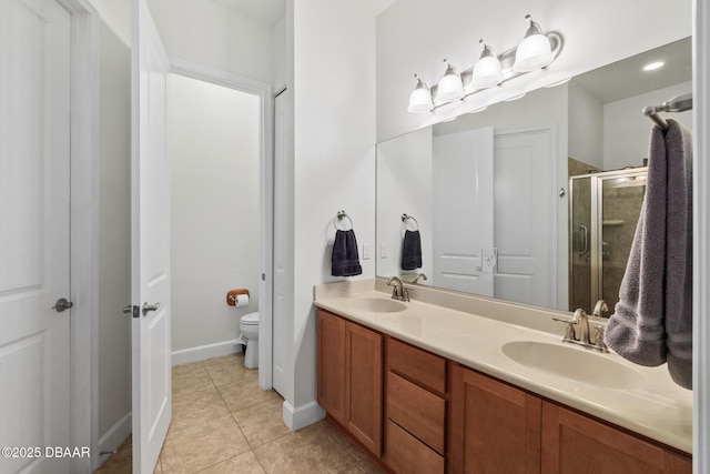 bathroom featuring a sink, toilet, a shower stall, and tile patterned flooring