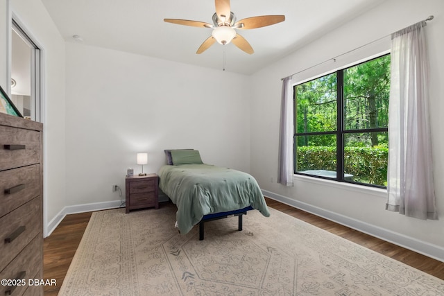 bedroom featuring dark wood finished floors, ceiling fan, and baseboards