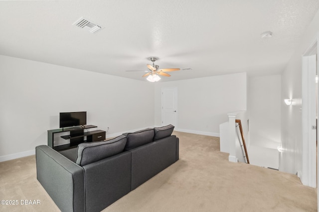 living area featuring light carpet, visible vents, a ceiling fan, and baseboards