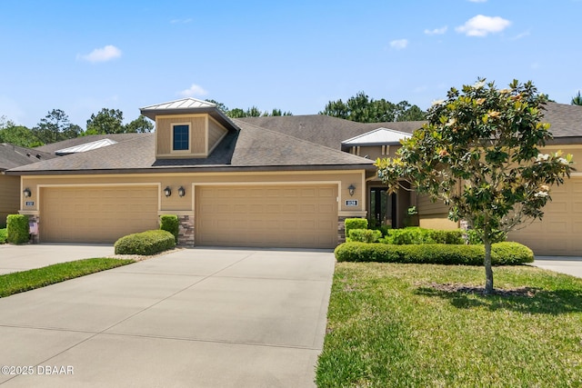 view of front of home with driveway, an attached garage, a front lawn, and metal roof