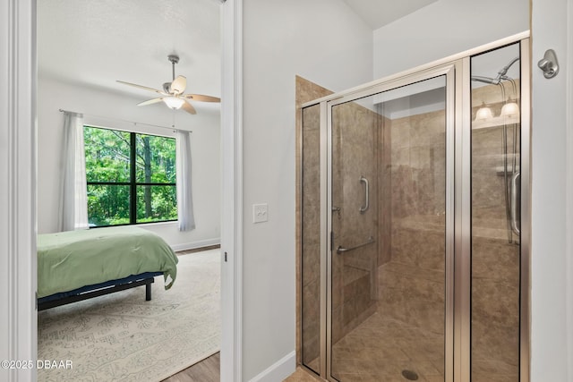 ensuite bathroom with a shower stall, ensuite bath, baseboards, and wood finished floors