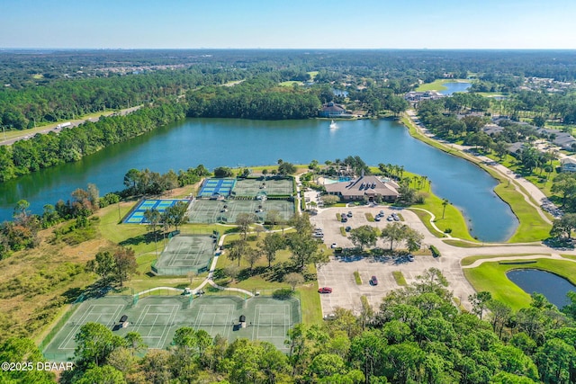 drone / aerial view featuring a wooded view and a water view