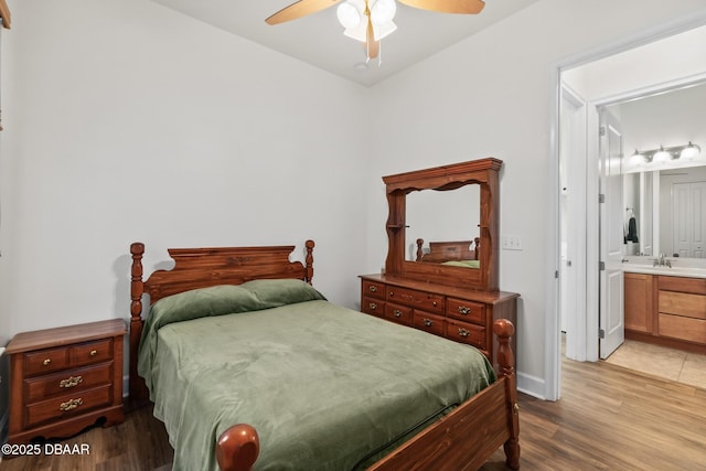 bedroom featuring a sink, connected bathroom, ceiling fan, and wood finished floors