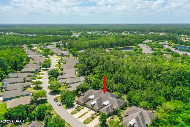 aerial view featuring a residential view, a wooded view, and a water view