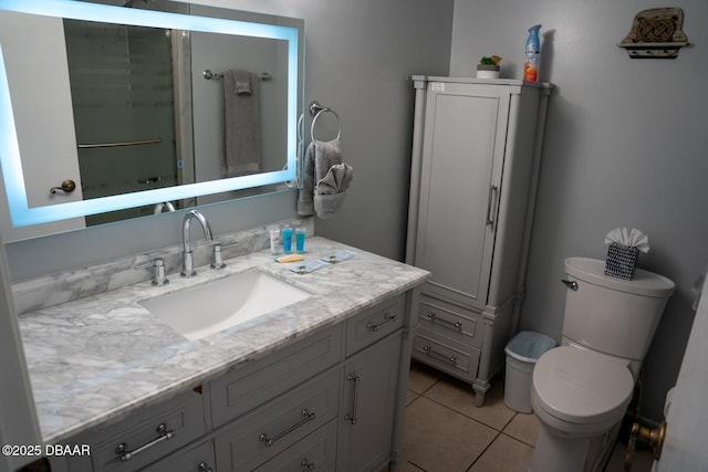 bathroom with vanity, tile patterned flooring, a shower with shower door, and toilet