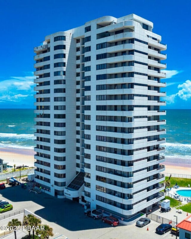 view of building exterior with a water view and a view of the beach