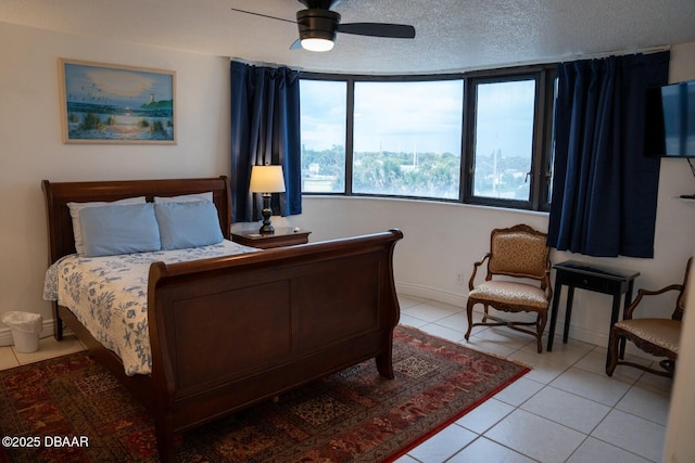 tiled bedroom with ceiling fan and a textured ceiling