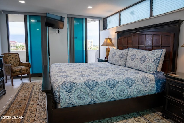 bedroom featuring expansive windows and light tile patterned floors