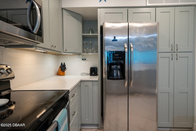 kitchen featuring tasteful backsplash, appliances with stainless steel finishes, and gray cabinets