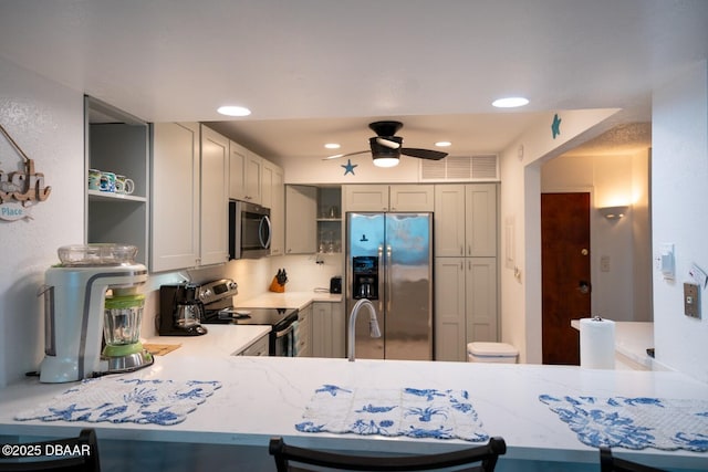 kitchen with sink, gray cabinetry, appliances with stainless steel finishes, kitchen peninsula, and ceiling fan