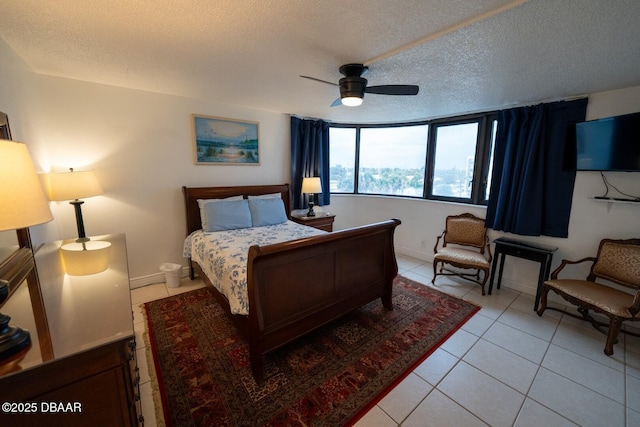 tiled bedroom with ceiling fan and a textured ceiling