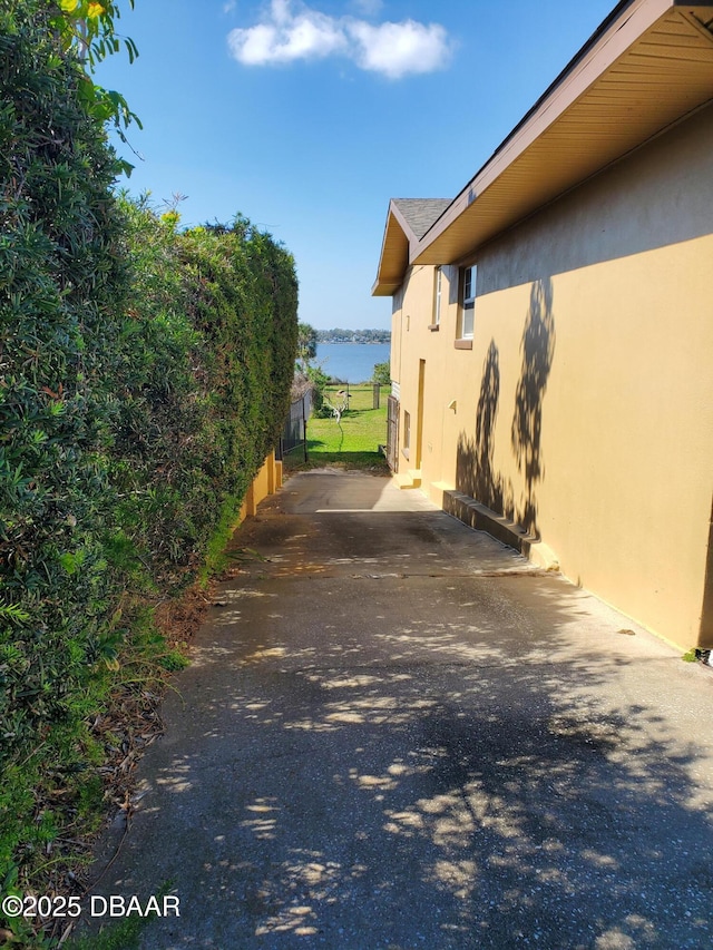 1199 N Halifax Ave, Daytona Beach, FL 32118 - view of side of property featuring stucco siding, a water view, and a patio