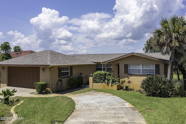 1199 N Halifax Ave, Daytona Beach, FL 32118 - ranch-style house with driveway, stucco siding, an attached garage, and a front lawn