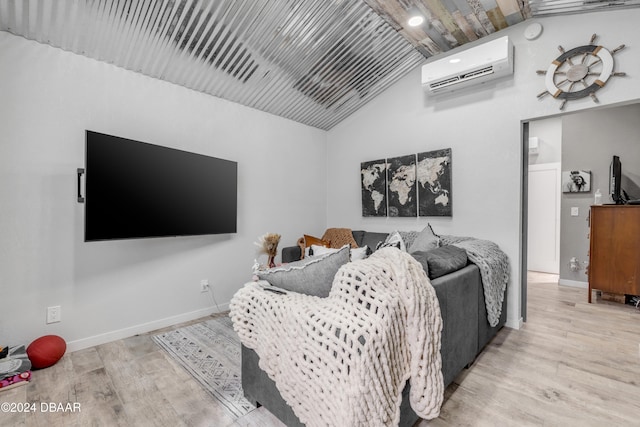 bedroom featuring vaulted ceiling, a wall mounted air conditioner, and light hardwood / wood-style floors