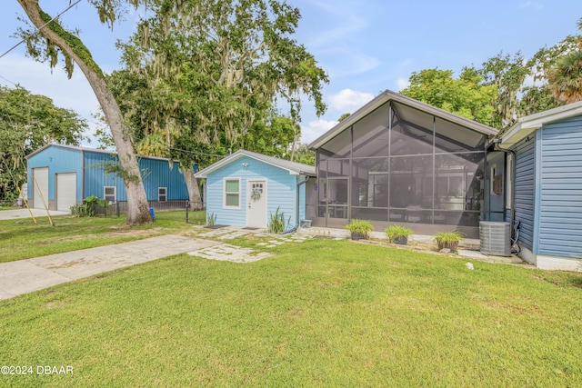 view of yard with an outbuilding, a garage, and central AC