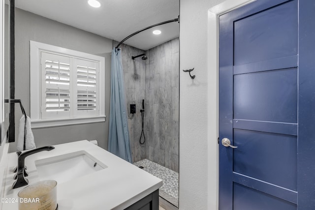 bathroom featuring vanity, walk in shower, and a textured ceiling