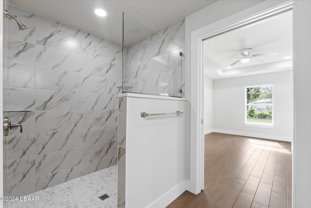 bathroom featuring a tile shower and ceiling fan