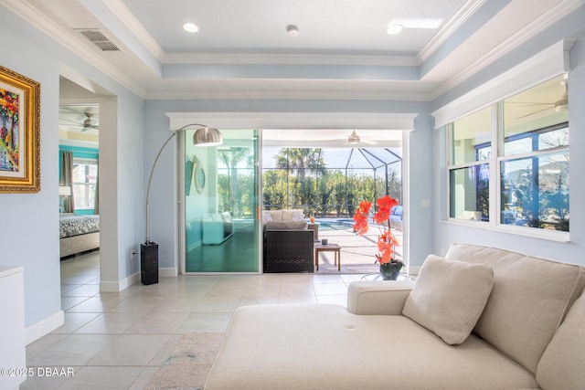 living room featuring a raised ceiling, crown molding, light tile patterned floors, and ceiling fan