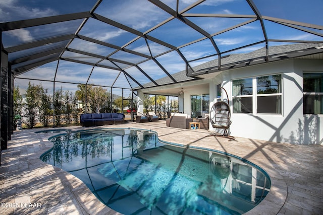 view of pool with outdoor lounge area, ceiling fan, a lanai, and a patio area