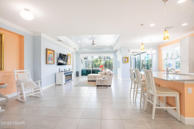 tiled living room featuring ornamental molding, sink, and a wealth of natural light