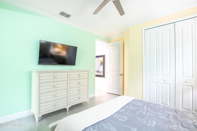 bedroom with tile patterned flooring, crown molding, ceiling fan, and a closet