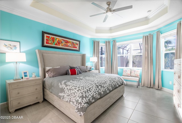 tiled bedroom featuring a tray ceiling, ornamental molding, and ceiling fan