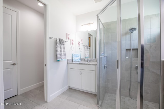 bathroom featuring vanity, a shower with shower door, and tile patterned flooring