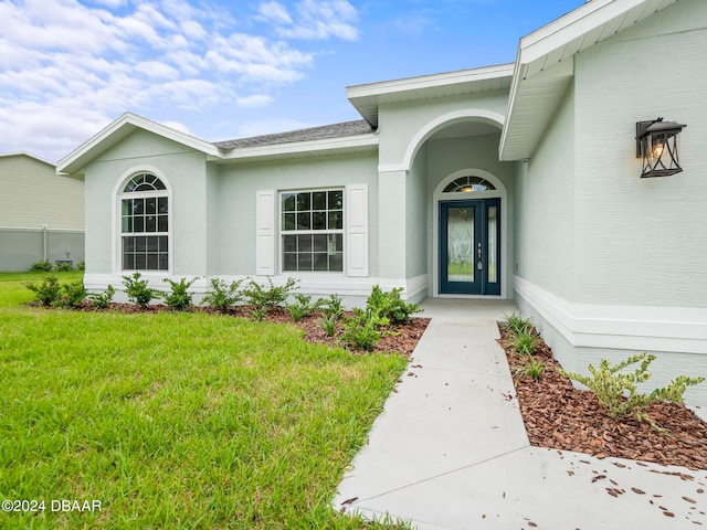 doorway to property featuring a yard