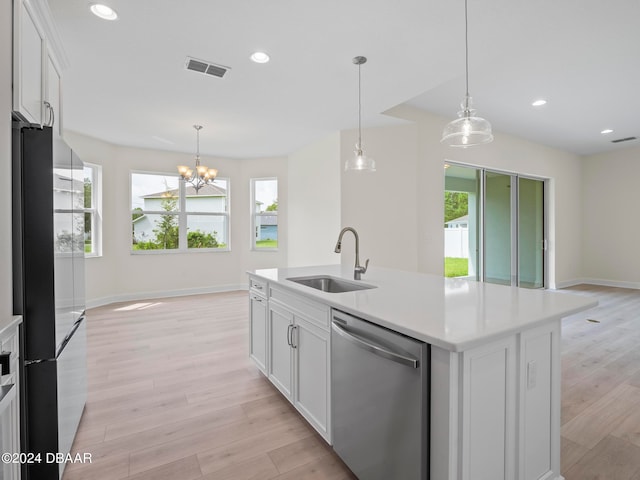 kitchen featuring a healthy amount of sunlight, appliances with stainless steel finishes, sink, and an island with sink