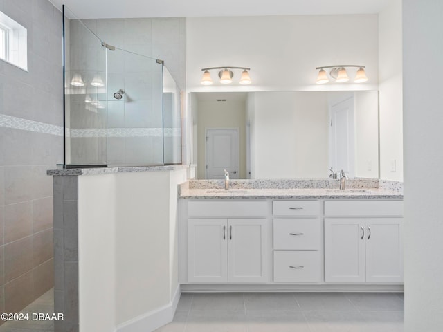 bathroom featuring vanity, tile patterned floors, and a tile shower