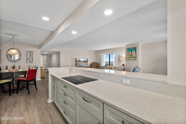 kitchen with light wood-style flooring, black electric stovetop, light countertops, and recessed lighting