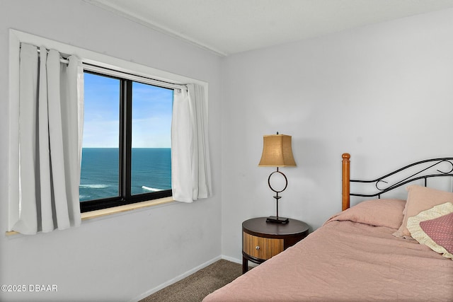 bedroom with carpet floors, a water view, and baseboards