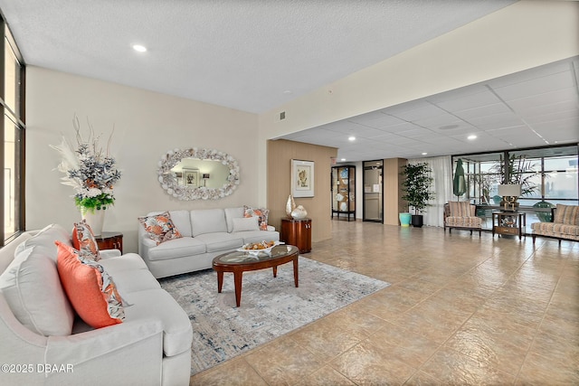 living room featuring a textured ceiling, visible vents, and recessed lighting