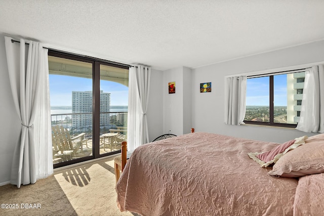 bedroom with a textured ceiling, floor to ceiling windows, carpet flooring, and access to exterior